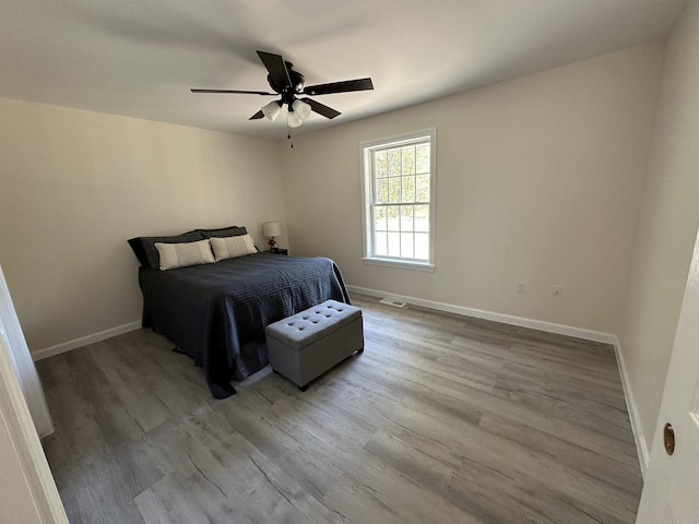 bedroom with wood finished floors, baseboards, and a ceiling fan