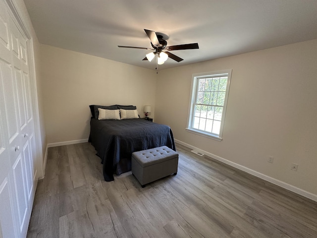 bedroom with wood finished floors, baseboards, and ceiling fan