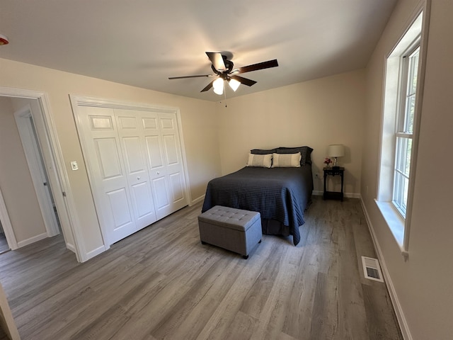bedroom featuring wood finished floors, baseboards, and a closet