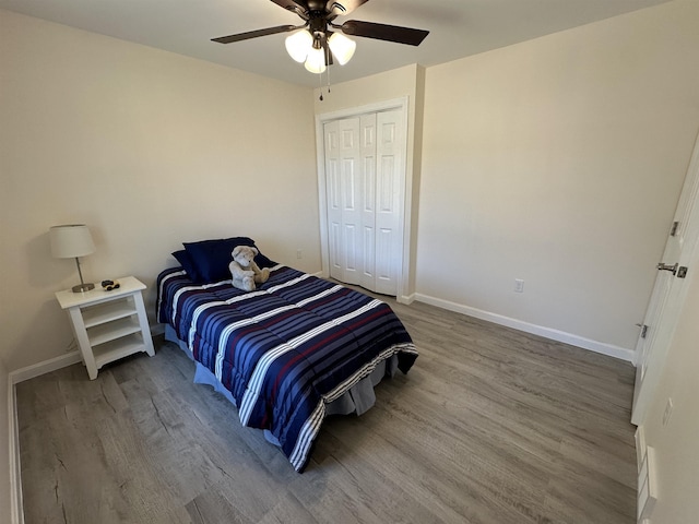 bedroom featuring wood finished floors, baseboards, a closet, and ceiling fan