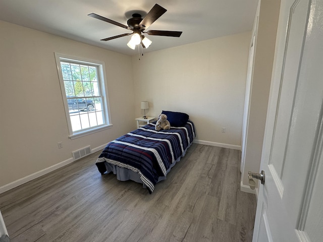 bedroom with wood finished floors, baseboards, and a ceiling fan