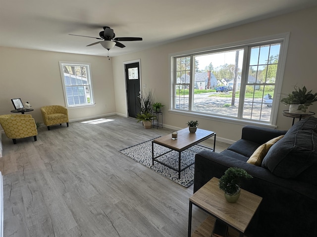 living room with wood finished floors, baseboards, and ceiling fan
