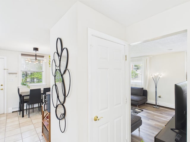 8 Lincoln Dr Unit B, Hooksett, NH 03106 - hallway featuring plenty of natural light, baseboard heating, baseboards, and a chandelier