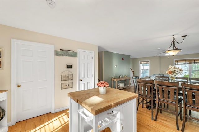 kitchen featuring wooden counters, healthy amount of natural light, light wood finished floors, and white cabinets