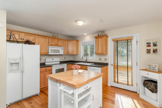 kitchen with white appliances, a sink, light wood-style floors, and wooden counters