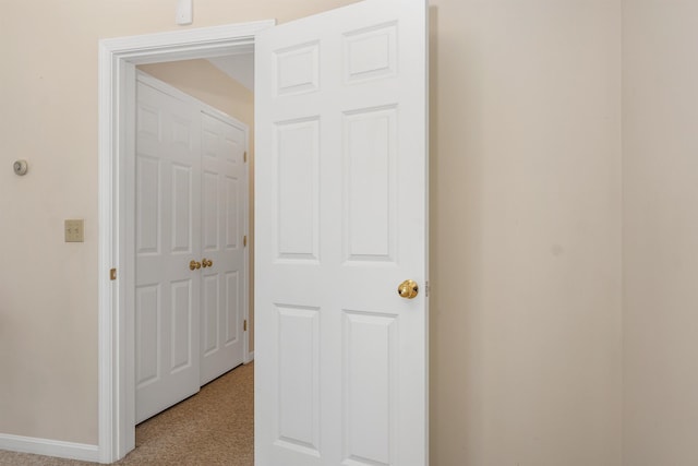 hall with light carpet and baseboards