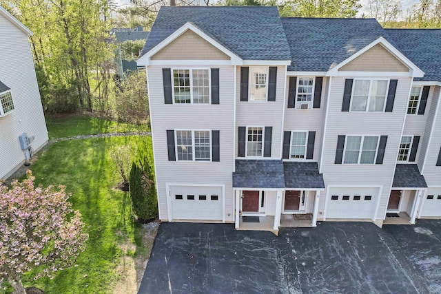view of front of property with a garage, driveway, and roof with shingles