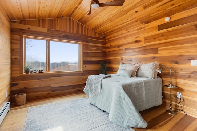 121 Ridge Ln, Westmore, VT 05860 - bedroom with wood walls, a baseboard radiator, lofted ceiling, wooden ceiling, and wood finished floors