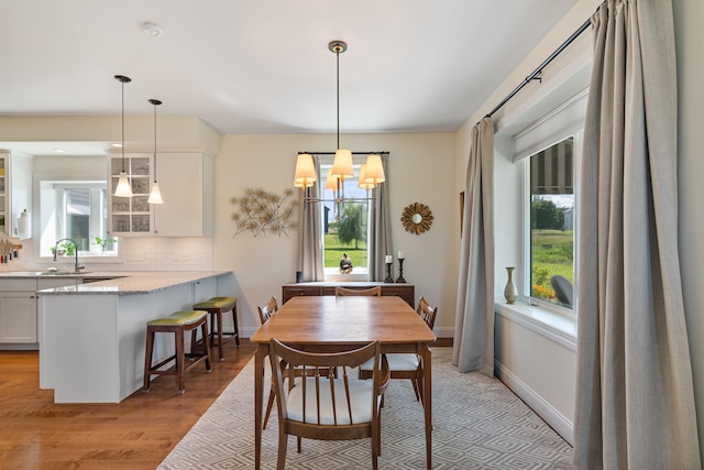 dining room featuring plenty of natural light, light wood-type flooring, and a chandelier