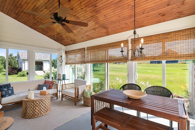 sunroom featuring a ceiling fan, vaulted ceiling, and a chandelier