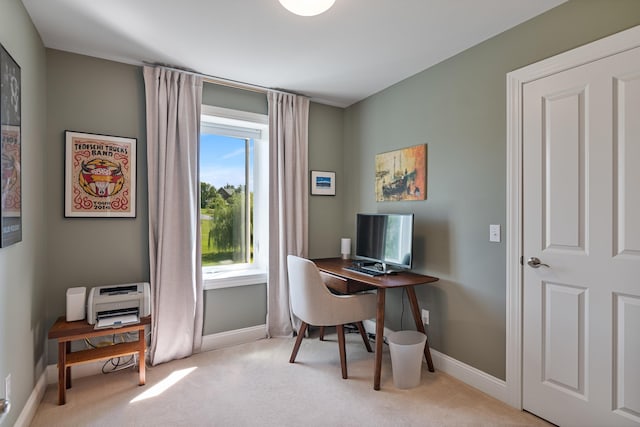 office area featuring baseboards and light carpet