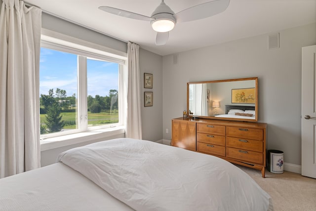 bedroom with multiple windows, light carpet, baseboards, and ceiling fan