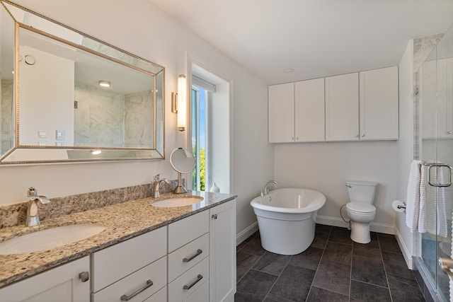 full bathroom featuring a stall shower, double vanity, baseboards, toilet, and a freestanding bath