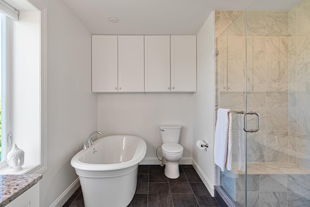 full bathroom with baseboards, a shower stall, a freestanding bath, toilet, and tile patterned floors