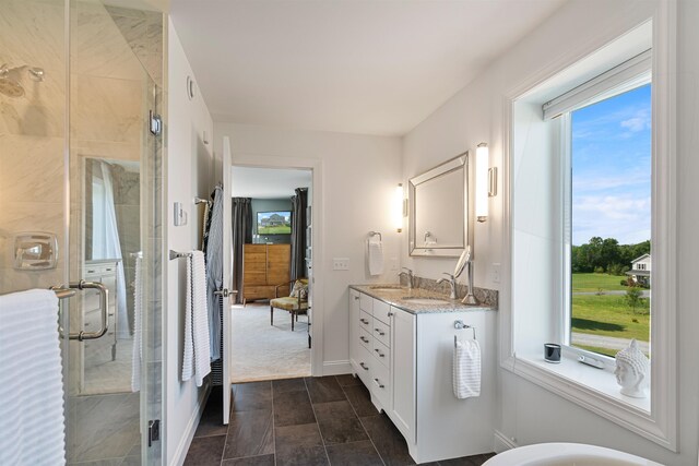 full bathroom featuring a shower stall, vanity, baseboards, and stone finish floors