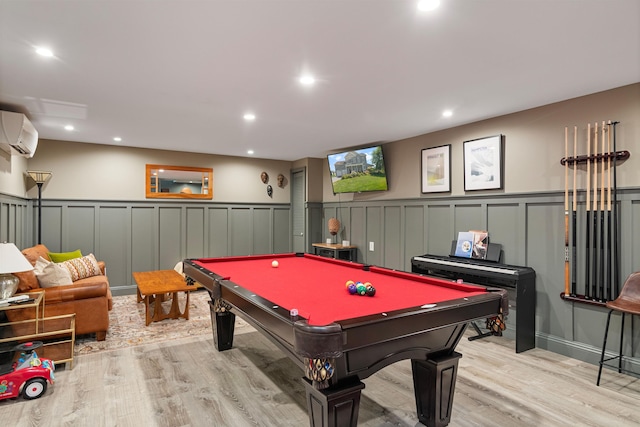 recreation room with a wall unit AC, a decorative wall, wood finished floors, wainscoting, and billiards
