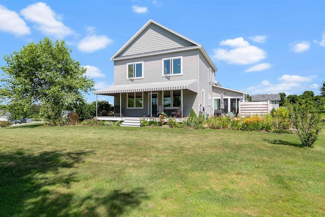 rear view of property featuring a lawn