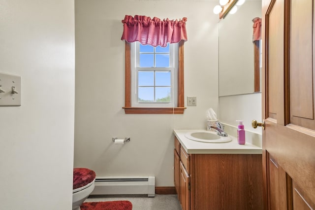 half bathroom with a baseboard radiator, toilet, vanity, and baseboards