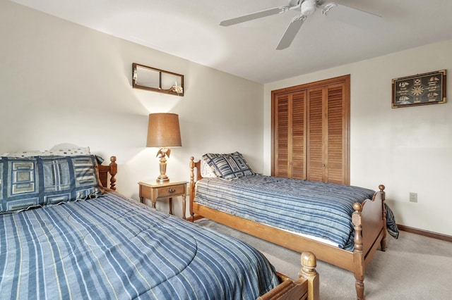 carpeted bedroom with a closet, baseboards, and a ceiling fan