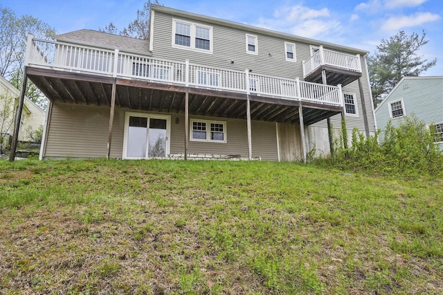 rear view of property featuring a deck and a yard