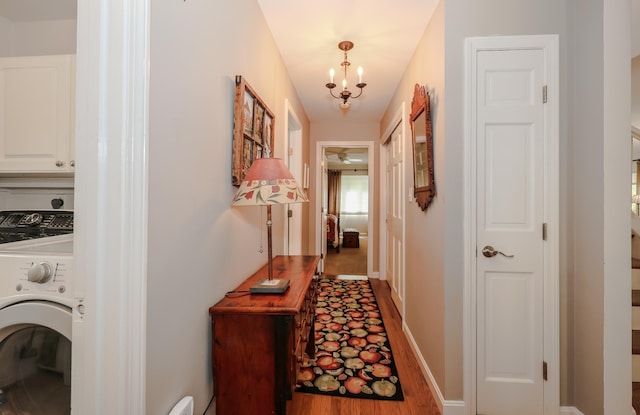 203 Straw Hill Rd, Manchester, NH 03104 - hall with washer / dryer, a chandelier, and wood finished floors