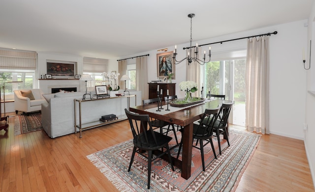 203 Straw Hill Rd, Manchester, NH 03104 - dining area featuring light wood-type flooring, a chandelier, and a fireplace