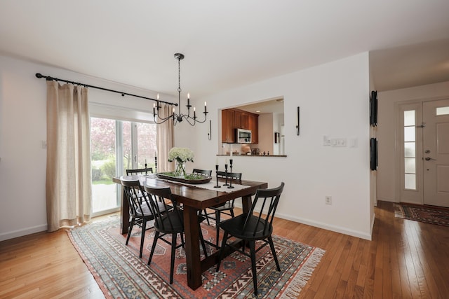 203 Straw Hill Rd, Manchester, NH 03104 - dining space featuring a chandelier, light wood finished floors, and baseboards