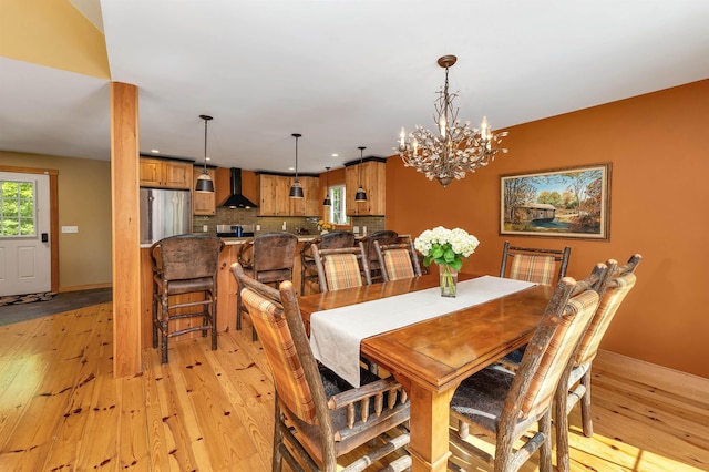 dining room with a chandelier, light wood-style flooring, recessed lighting, and baseboards