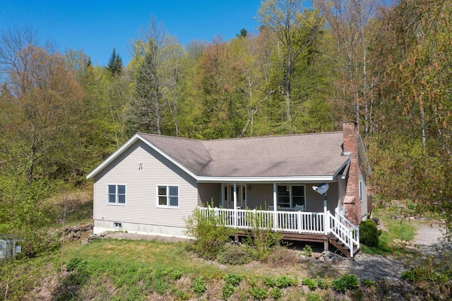 273 Berkshire Rd, Lisbon, NH 03585 - view of front facade with covered porch, a chimney, and a forest view