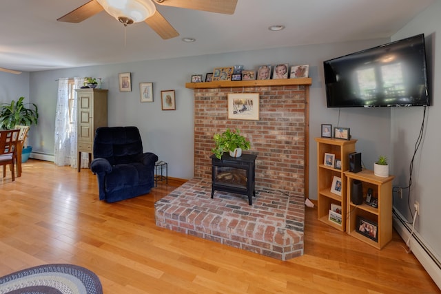 273 Berkshire Rd, Lisbon, NH 03585 - living room featuring a baseboard radiator, light wood-style floors, a ceiling fan, a wood stove, and recessed lighting