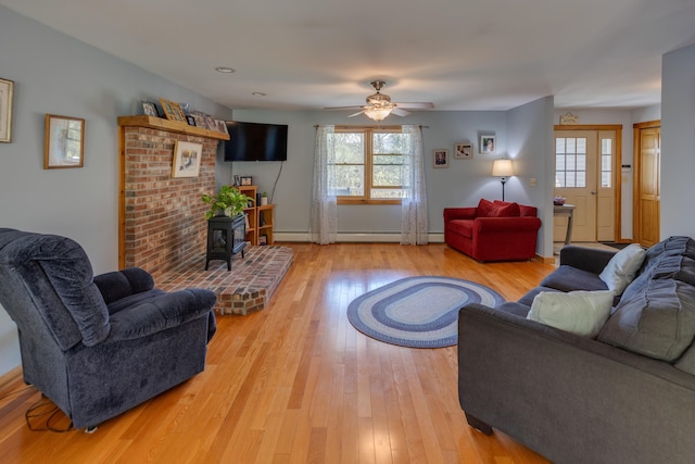 273 Berkshire Rd, Lisbon, NH 03585 - living area with a wood stove, plenty of natural light, a ceiling fan, and light wood-style floors