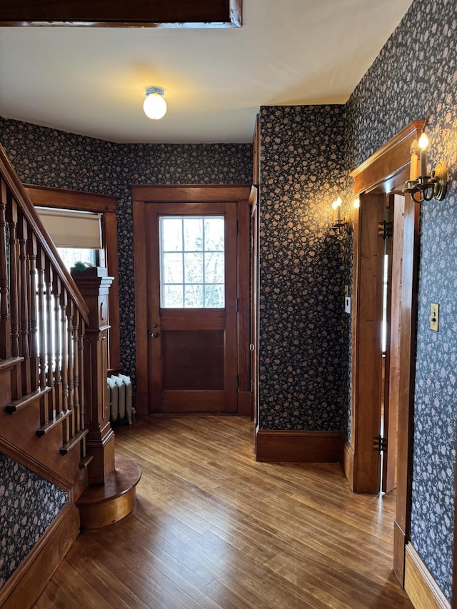 76 Center St, Richford, VT 05476 - foyer entrance with wallpapered walls, wood finished floors, stairway, and radiator heating unit