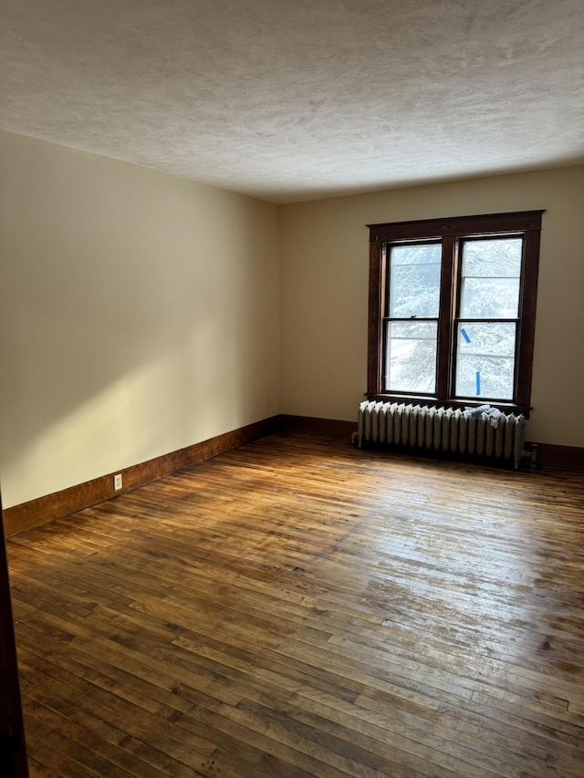 76 Center St, Richford, VT 05476 - spare room featuring radiator, dark wood finished floors, and a textured ceiling