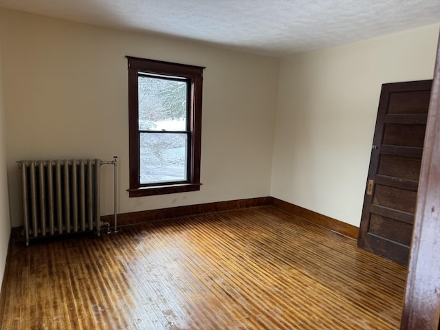 76 Center St, Richford, VT 05476 - empty room featuring radiator, wood-type flooring, and a textured ceiling