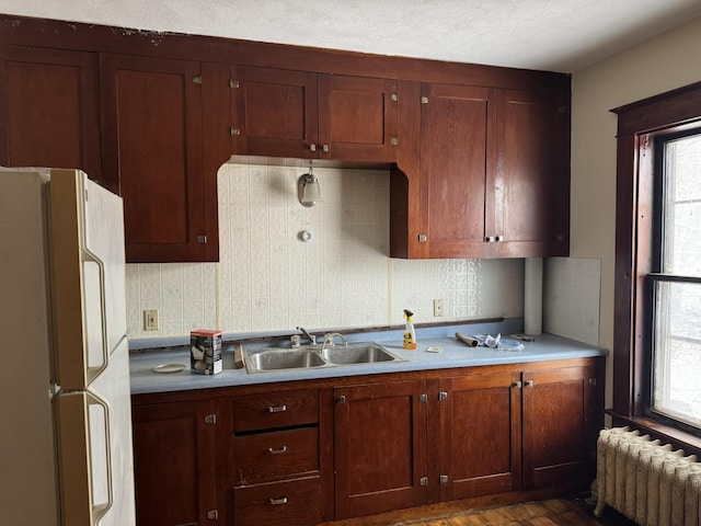 76 Center St, Richford, VT 05476 - kitchen featuring freestanding refrigerator, radiator, decorative backsplash, and light countertops