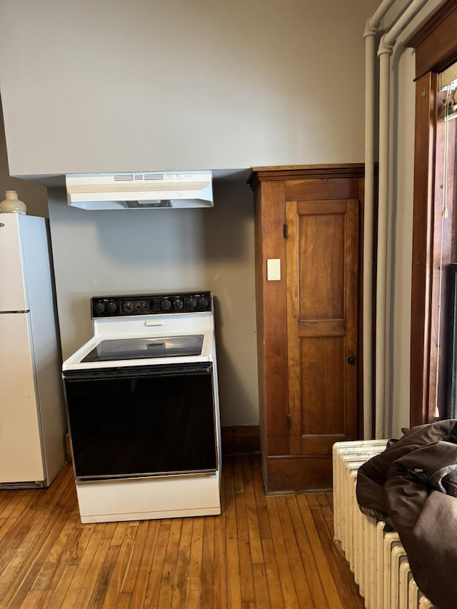 76 Center St, Richford, VT 05476 - kitchen featuring range with electric stovetop, freestanding refrigerator, ventilation hood, and hardwood / wood-style flooring