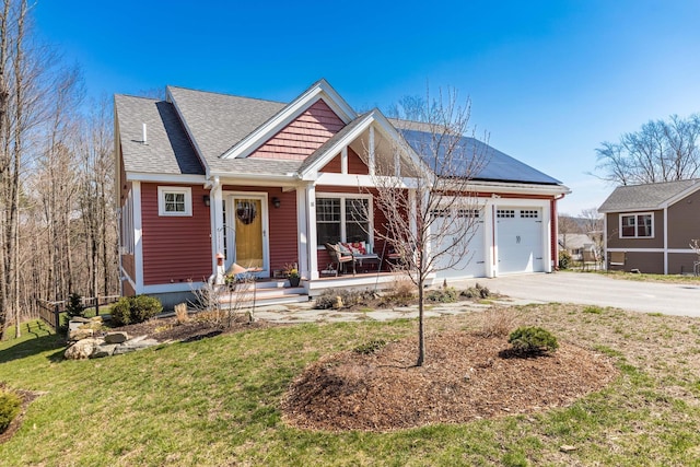 view of front of property featuring concrete driveway, a front lawn, an attached garage, a shingled roof, and roof mounted solar panels