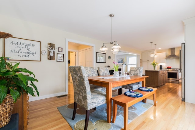 dining room featuring light wood-style floors and baseboards