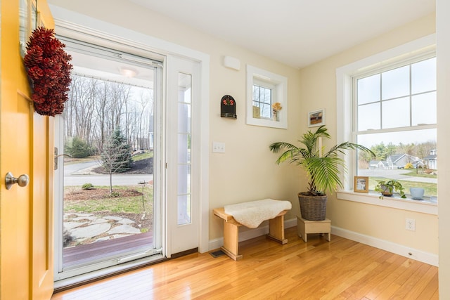 foyer with light wood-style flooring and baseboards