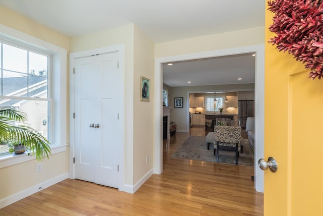foyer entrance with light wood finished floors, healthy amount of natural light, baseboards, and recessed lighting