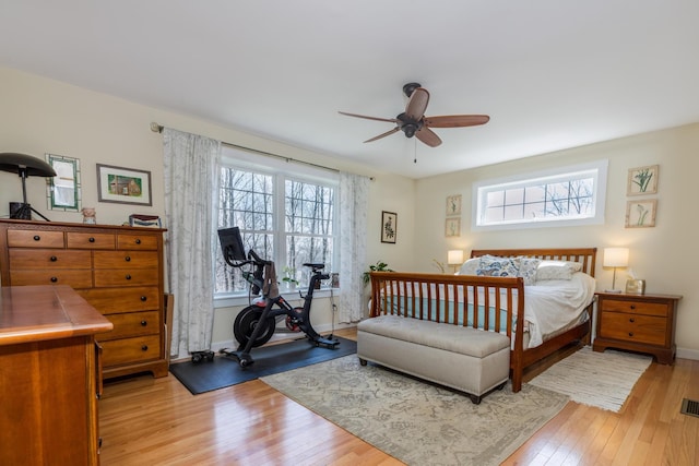 bedroom with multiple windows, light wood-style flooring, baseboards, and a ceiling fan