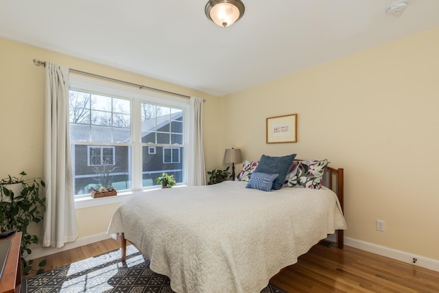 bedroom featuring baseboards and wood finished floors