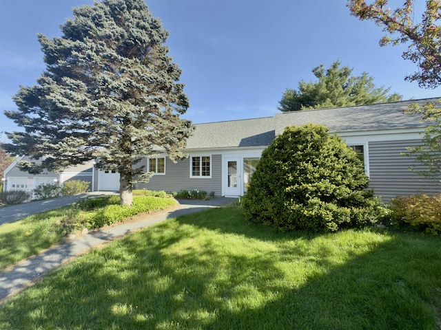 obstructed view of property featuring a front lawn and a garage