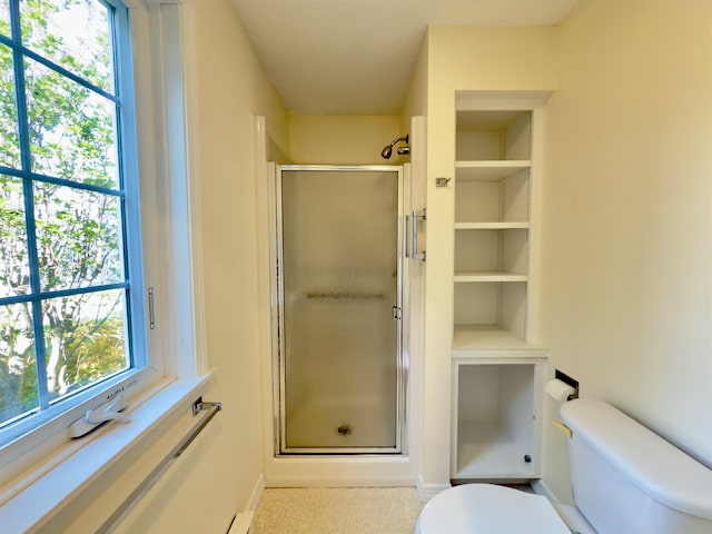 full bathroom featuring toilet, a shower stall, and baseboards