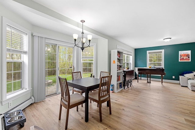 dining room with a chandelier, light wood-style flooring, and healthy amount of natural light