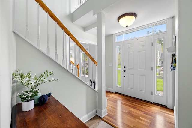 entrance foyer with stairs, wood finished floors, and baseboards