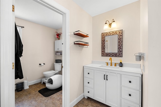 bathroom featuring vanity, toilet, and baseboards