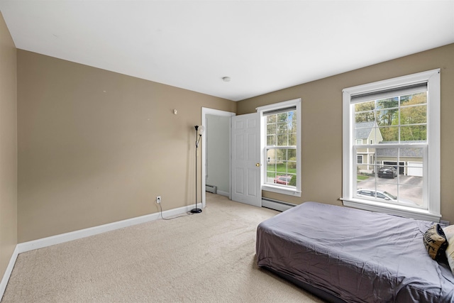 bedroom with a baseboard radiator, baseboards, and light colored carpet