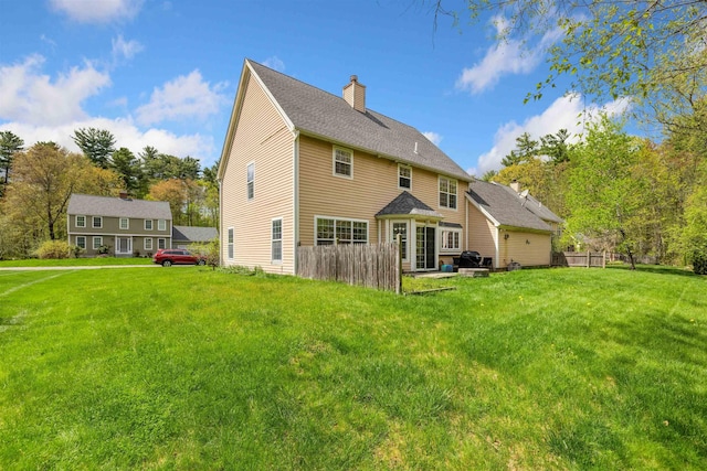 back of property featuring a chimney and a yard