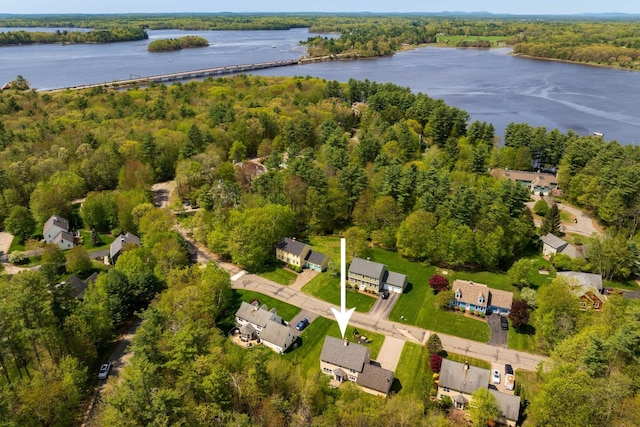 view of property location with a nearby body of water, a heavily wooded area, and nearby suburban area